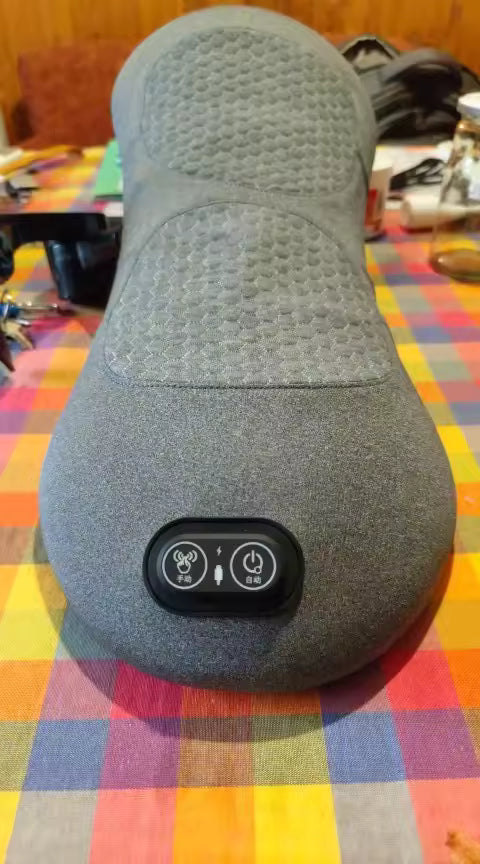 Gray massage pillow with control buttons on a colorful tablecloth